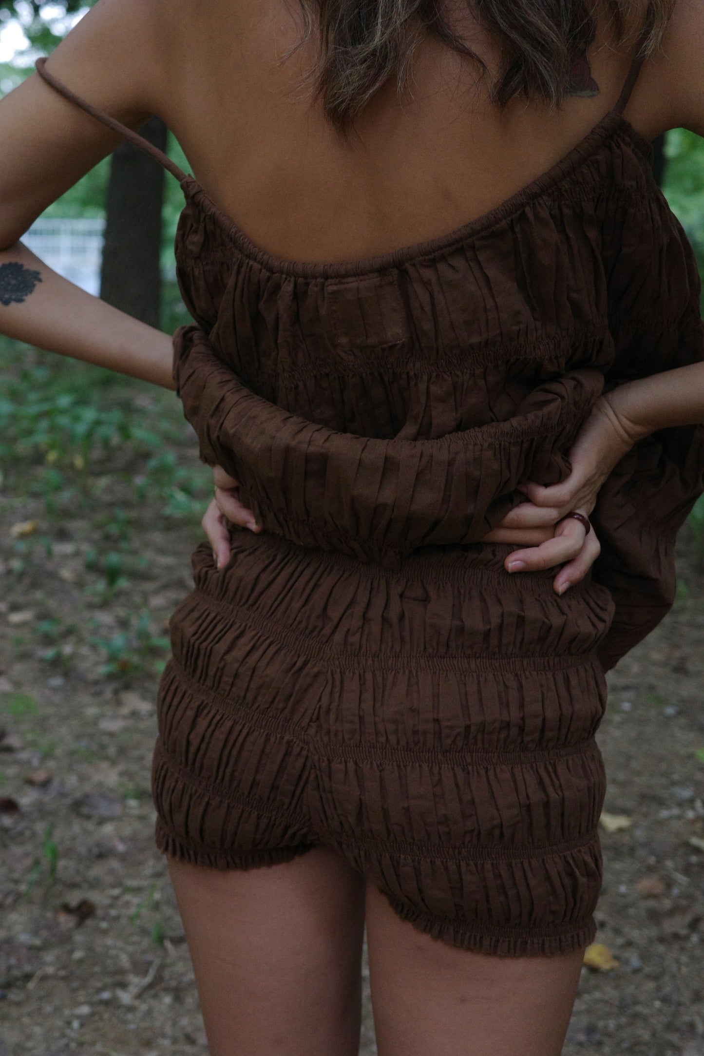 Brown textured shorts and sleeveless top worn by a person outdoors